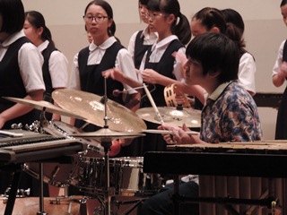 ドラムを叩く講師の野上さんの写真