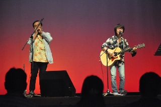 玉城まさゆきさんによるハーモニカとアコースティックギターの演奏の写真
