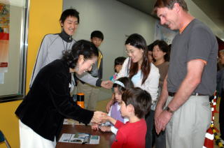 木村さんと握手する笑顔の子どもたち