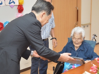 藤林さんにお祝いの賞状を手渡す井崎市長の写真