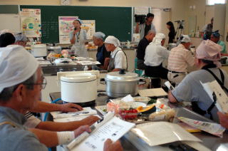 レシピを見ながら料理に挑戦する参加者