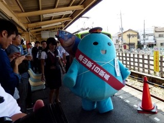 1日駅長としてホームを歩く魚心君の写真