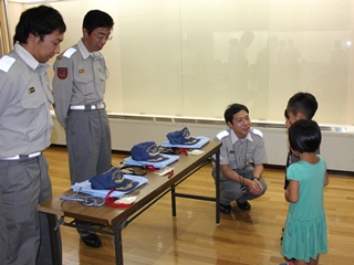 ギャラリーで資器材の説明をする隊員と説明を聞く子どもの写真
