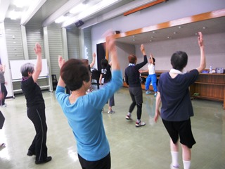 腕を振り上げる運動をする参加者の写真