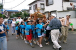 揃いのハッピで元気良く神輿を担ぐ子どもたち