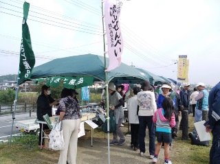 土手の上での産品販売の様子の写真