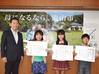 賞状を持った入賞者と市長の写真