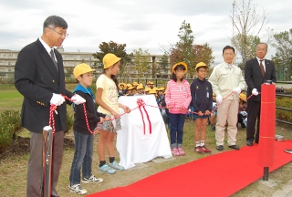 寄贈された看板の除幕式の写真