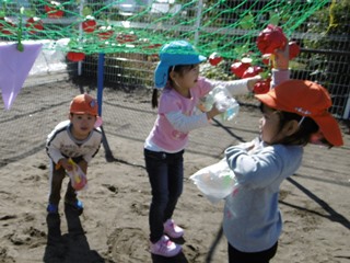 紙のフルーツを狩る子どもたちの写真