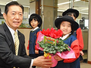 鉢植えを井崎市長に手渡す園児の写真