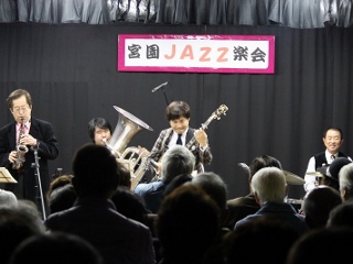 クラリネット奏者の花岡詠二さん、ドラマーの楠堂浩己さん、バンジョーの青木研さんの写真