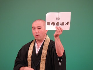 「生命」という文字を掲げる増田さんの写真