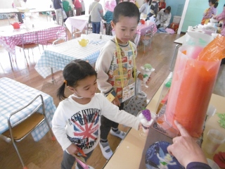 お兄さんが小さい子のサポートをしている写真