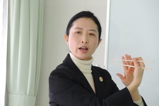 講師が箸の持ち方を指導する写真