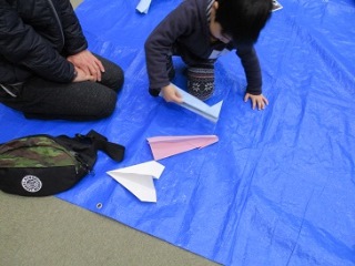 紙飛行機で遊ぶ子どもの写真