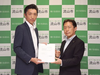 協定を締結した千葉銀行の流山支店長・成島崇さんと井崎市長の写真