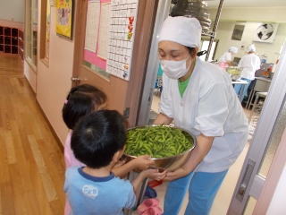 調理師さんから枝豆を預かる子どもたちの様子