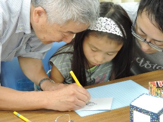 子どもにナイフの使い方を教える飯田さんの写真