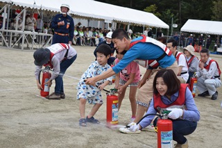 消火訓練に参加する親子の写真