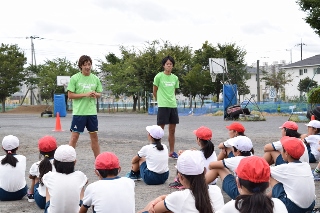 三田翔平さん、寺田克也さんから走り方を教わる生徒たちの写真