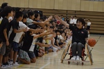 小学生とハイタッチする講師の根木さん