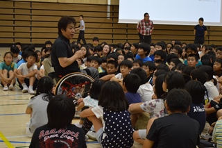小学生を集めて話をする根木さんの写真