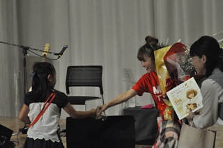 女の子と握手する加賀谷さんの写真