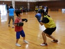 子どもとトレーニングするボクシング部の女生徒の写真