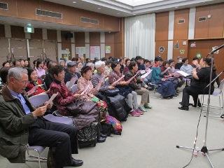 GONZAさんの指導で歌に参加する来場者の写真