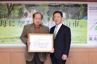 感謝状を持つ鈴木さんと井崎市長の写真