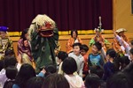 七福神と児童の間で舞う獅子舞の写真