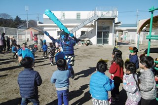 鬼に豆を投げる子どもたちの写真