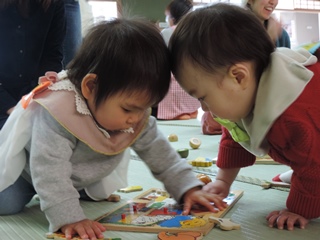 おもちゃを取り合う赤ちゃんの写真