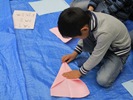 折り紙を折る子どもの写真