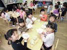 笑顔でおまんじゅうを持つ子どもたちの写真