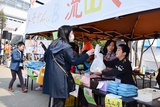 お客さんに商品を手渡す小学生の写真