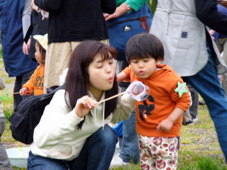 シャボン玉を飛ばす親子の写真