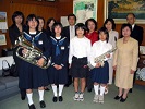 楽器を手にした児童生徒と音楽家会員、教育長の写真