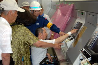 車椅子で切符を買う様子の写真