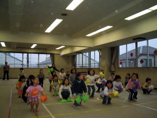 ポンポンを持って踊る子どもたちの写真