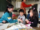 中学生と一緒に凧揚げをする小学生の写真