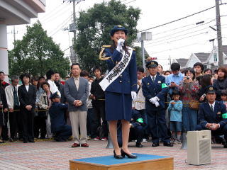 制服を着て挨拶をする小野真弓さんの写真