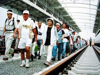 高架上の線路を歩く参加者の画像