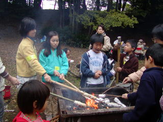 キャンプ場でバーベキューをする子どもたち