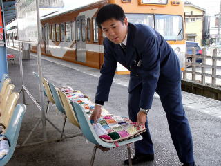 駅ホームに座布団を設置する駅員